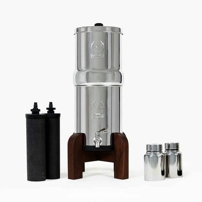 Stainless steel water filtration system with wooden base on a white background